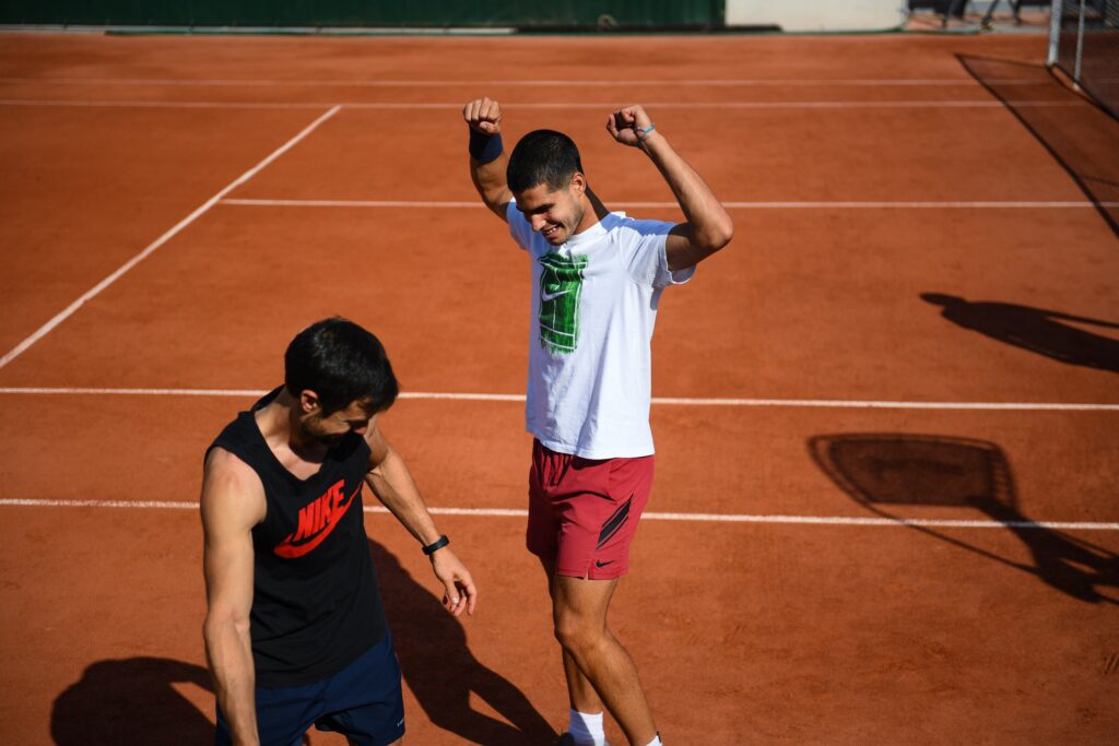 Carlos Alcaraz training with his team, preparing for his next match at Roland Garros, showcasing his focused recovery routine.