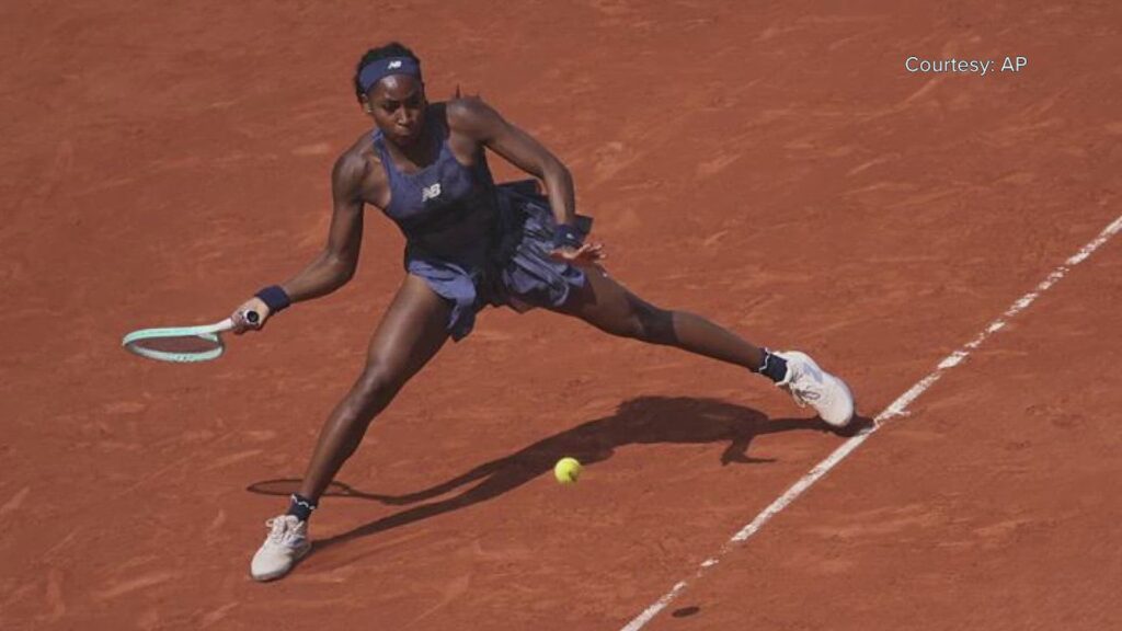 Alexander Zverev mid-match at the French Open 2025, reacting after swallowing a fly during play against Novak Djokovic.